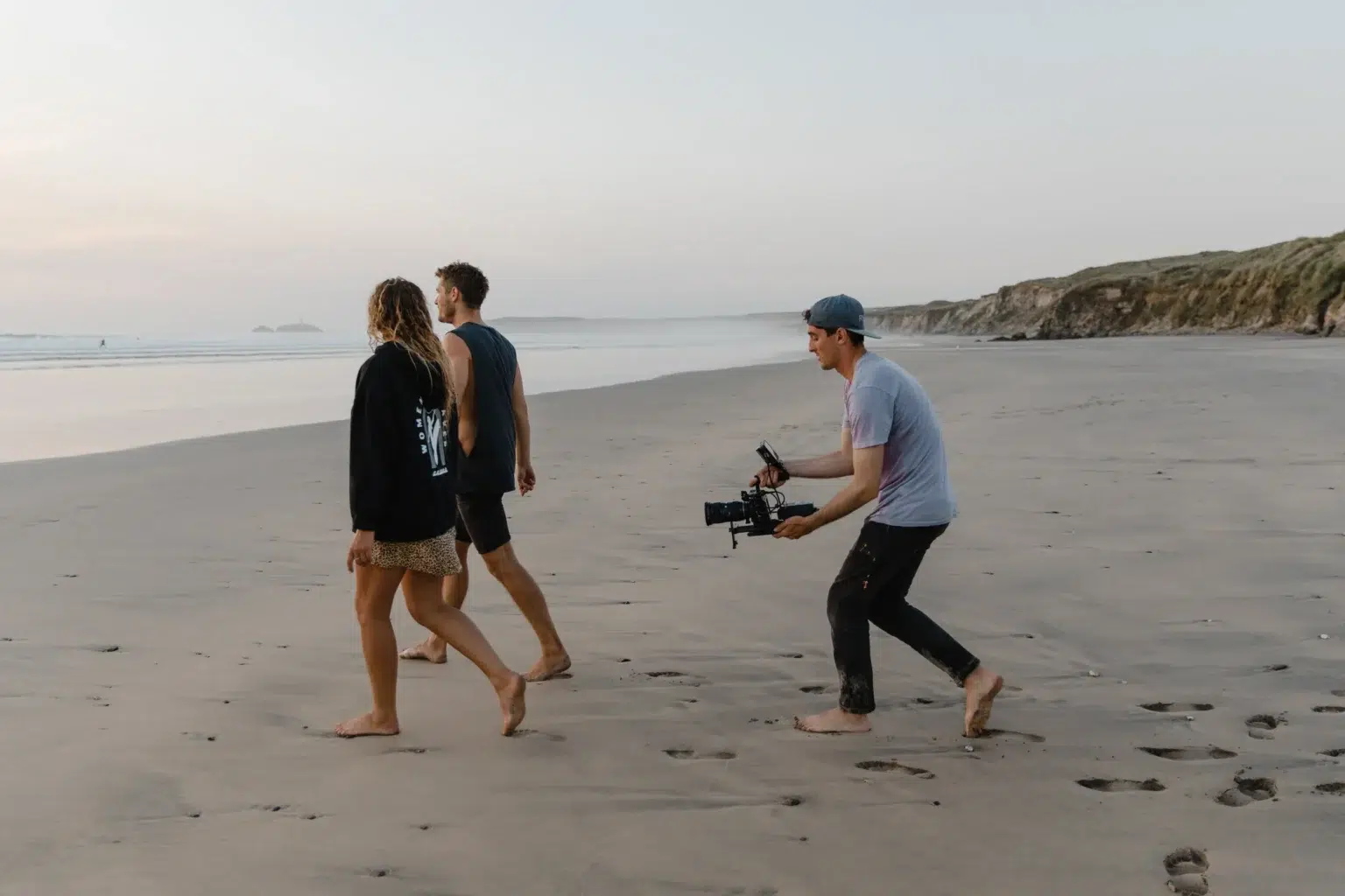Hire a gimbal operator in Manchester 1 A camera operator on a gimbal tracking two people walking along the shore