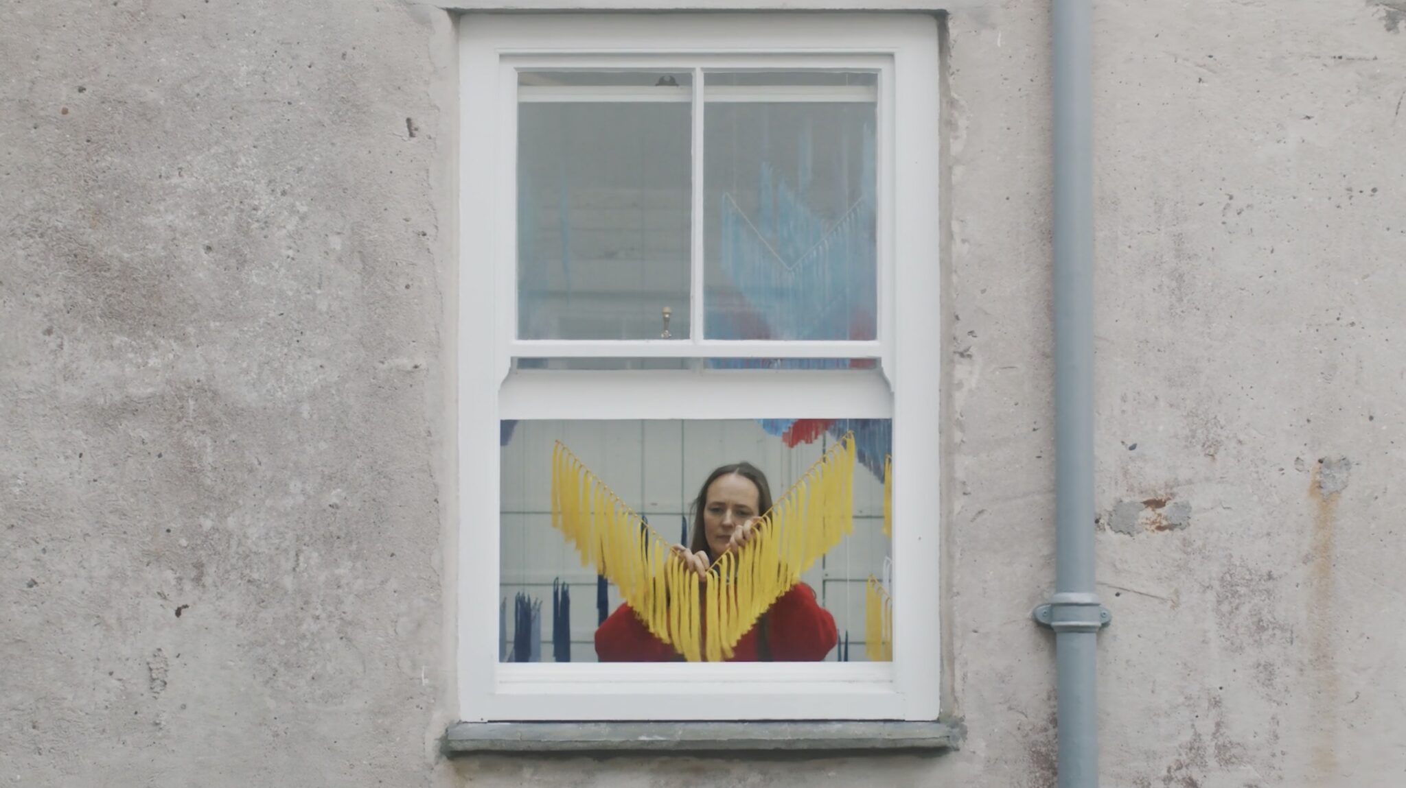 The artist Outi Pieski seen through her studio window