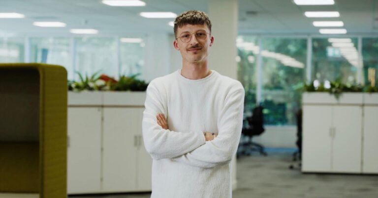 An image of a simply business employee with his arms crossed, smiling, looking straight into the barrel of the lense. Taken during a recent corporate video production for London Based client Centrical software.