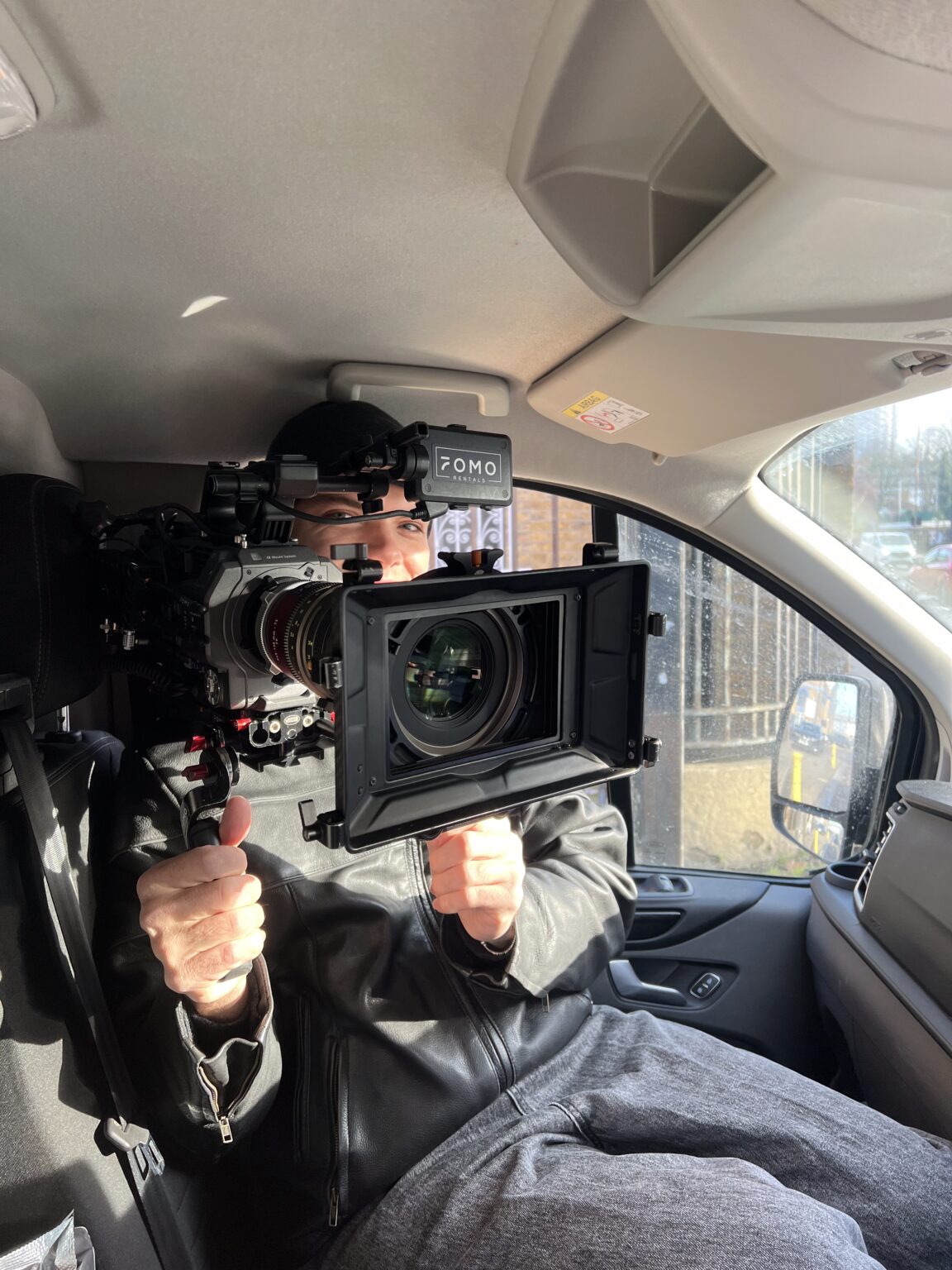 DIT and data for Manchester shoots 6 A camera operator in the crew van, rigged cinema camera pointed straight down the lens.
