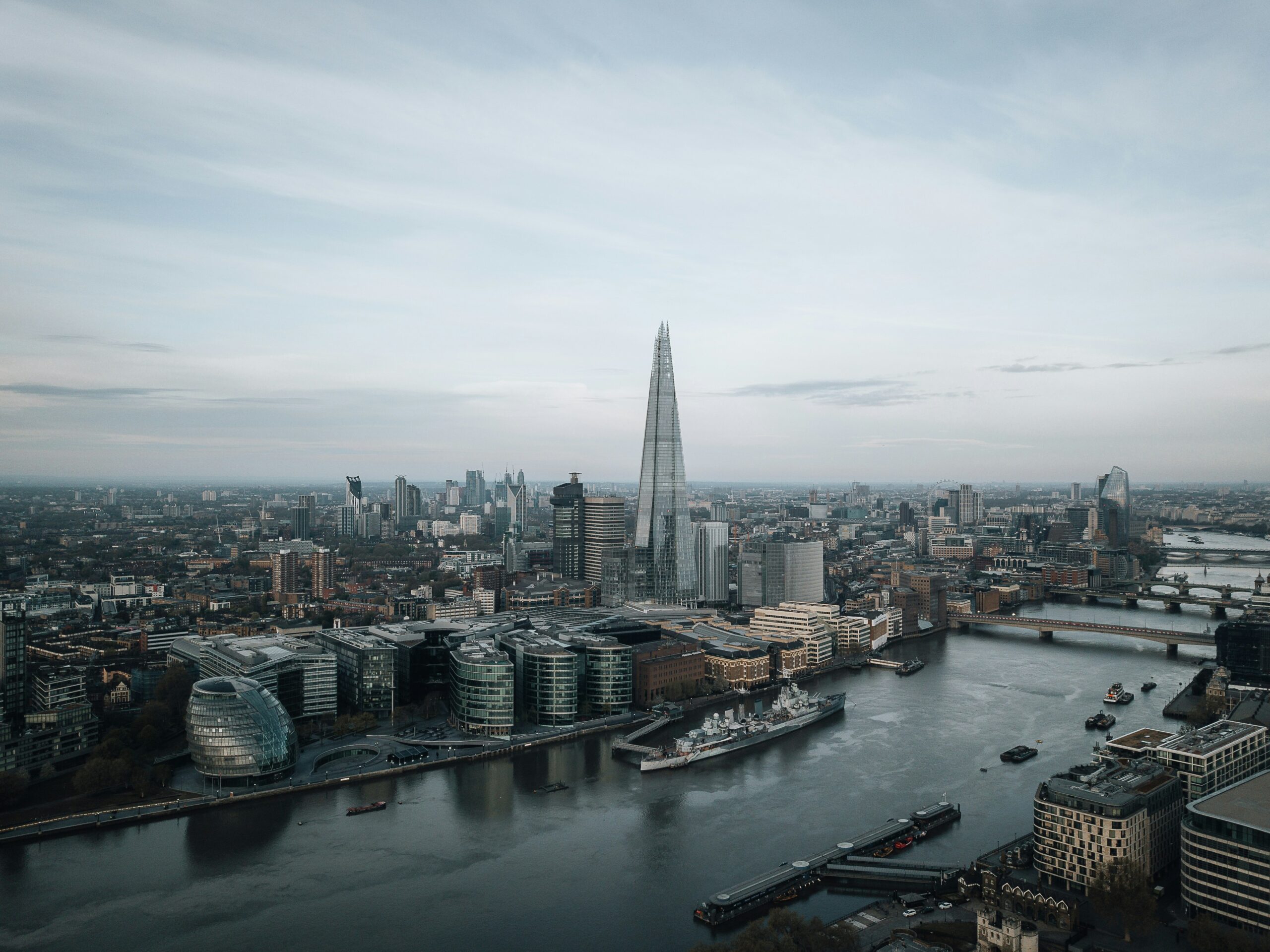 A drone shot of London bridge and the shard as the sun sets.