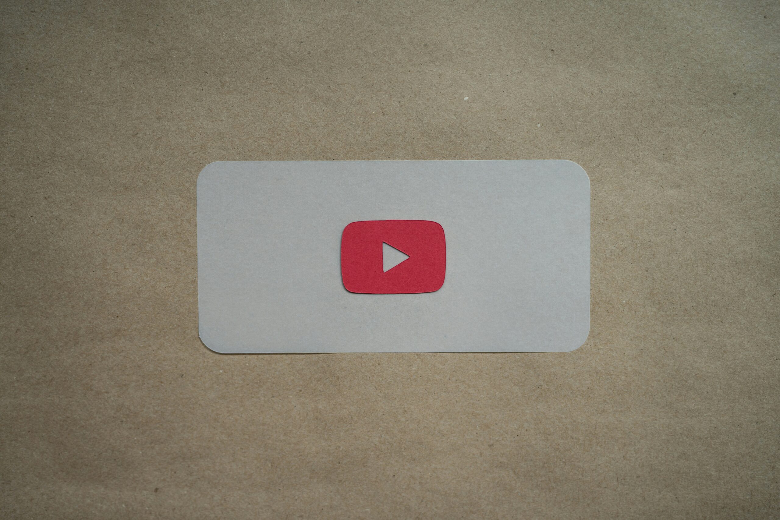 Video seo guide. An image of a YouTube logo on a pale brown background.