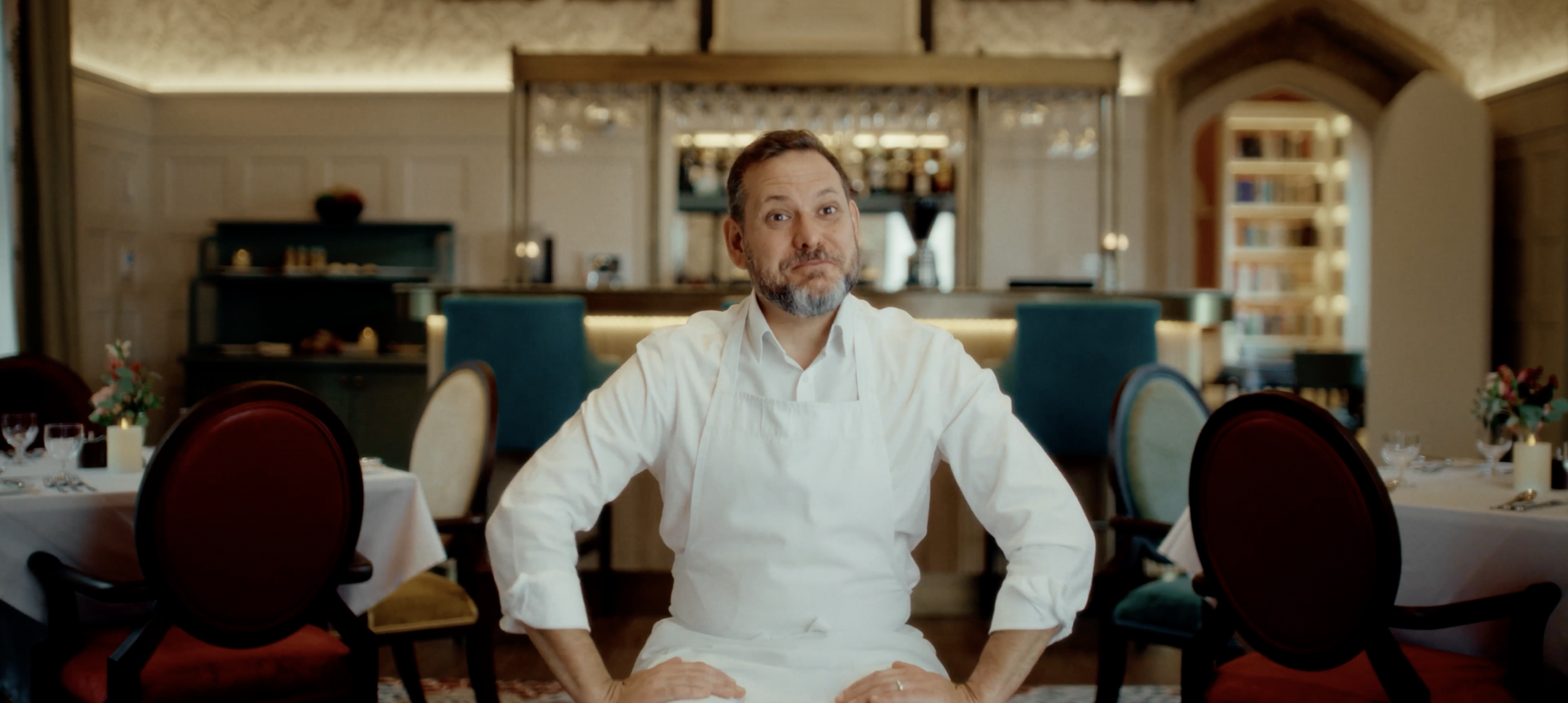 An image of Ed Smit, Managing Director of Here Now Films, on a film set with two piece signs.