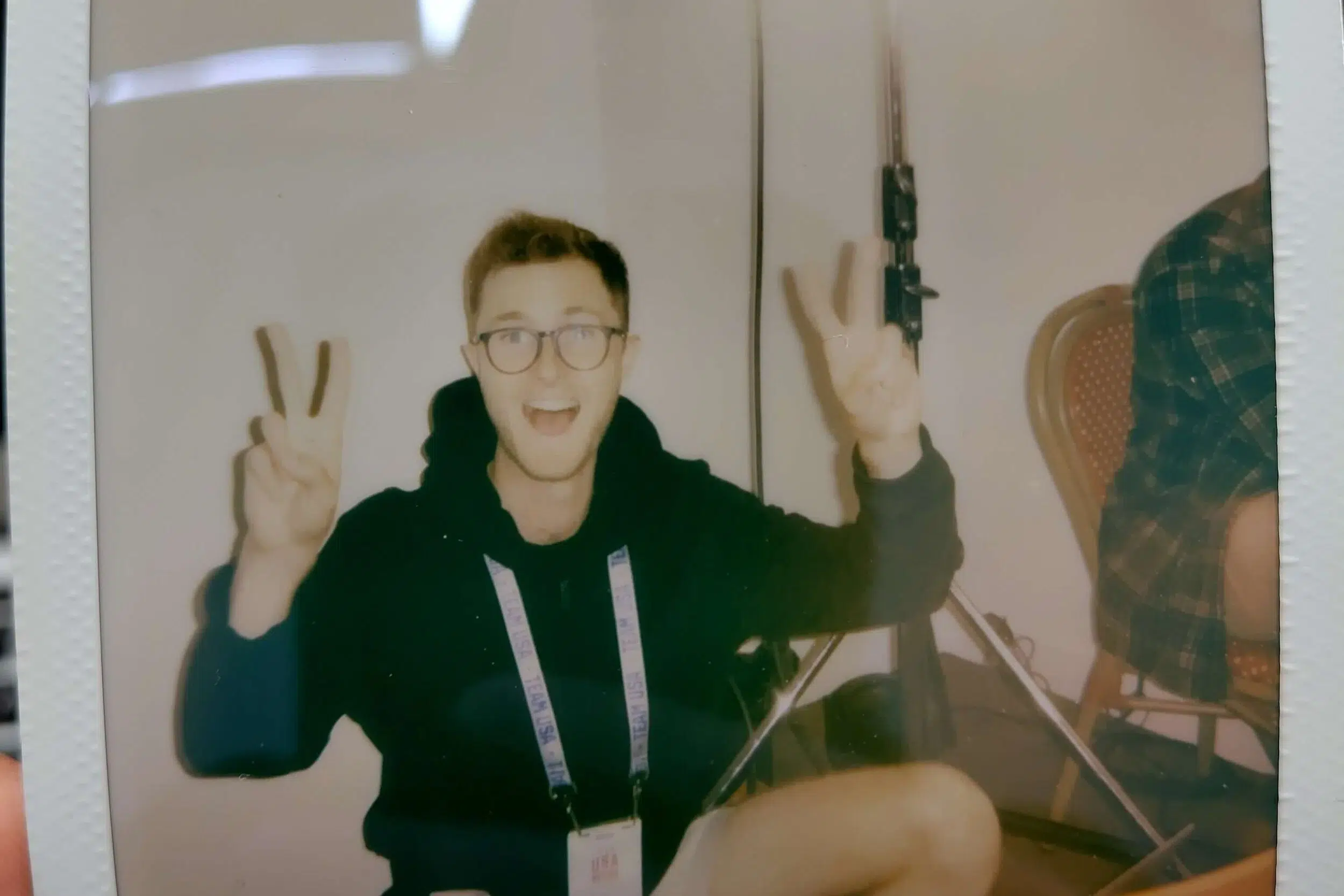 An image of Ed Smit, Managing Director of Here Now Films, on a film set with two piece signs.