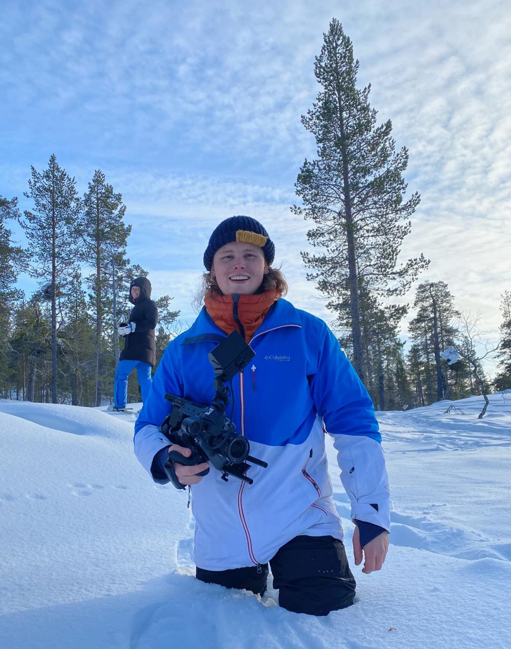 An image of Ed Smit, Managing Director of Here Now Films, on a film set with two piece signs.