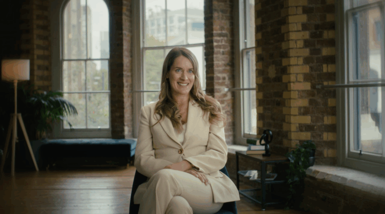 A picture of an AlTi global employee sitting on a char in centre frame in a red brick room