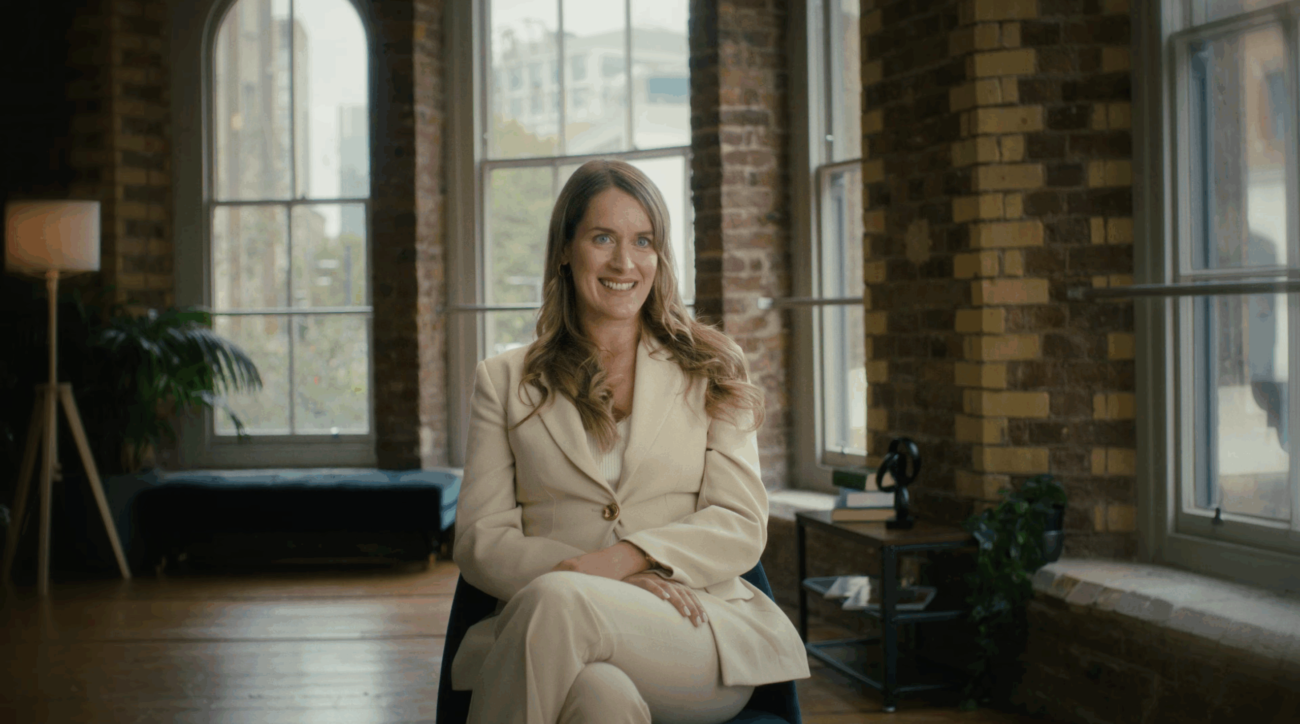 A picture of an AlTi global employee sitting on a char in centre frame in a red brick room