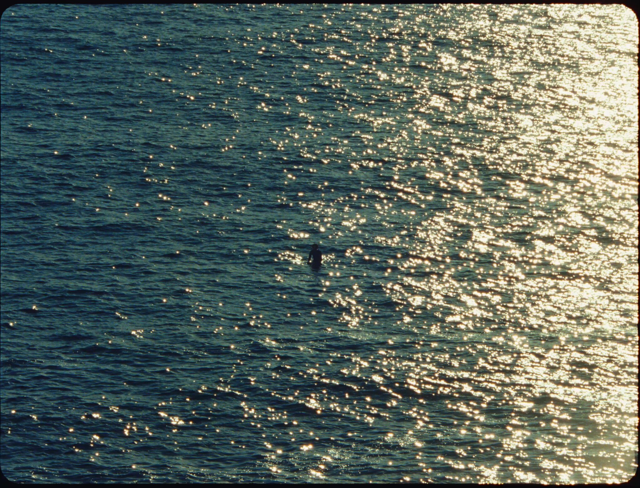 A lone figure in the Atlantic at dusk, from Cohere’s AI for Empowerment