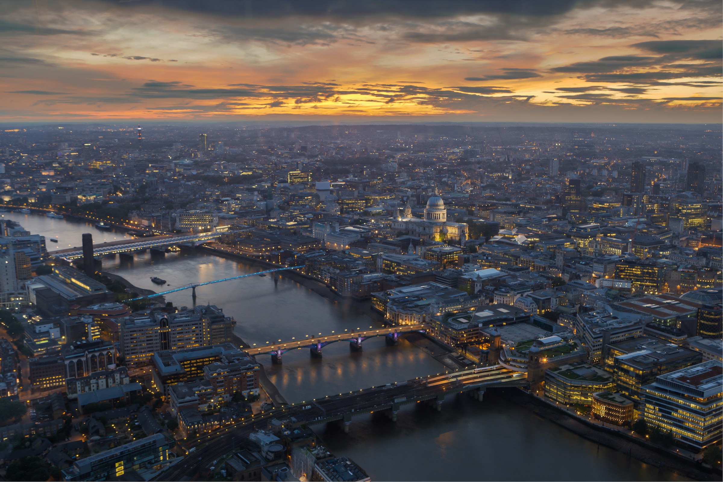 The City of London and St Paul’s from above at dusk, with the Thames and its bridges below