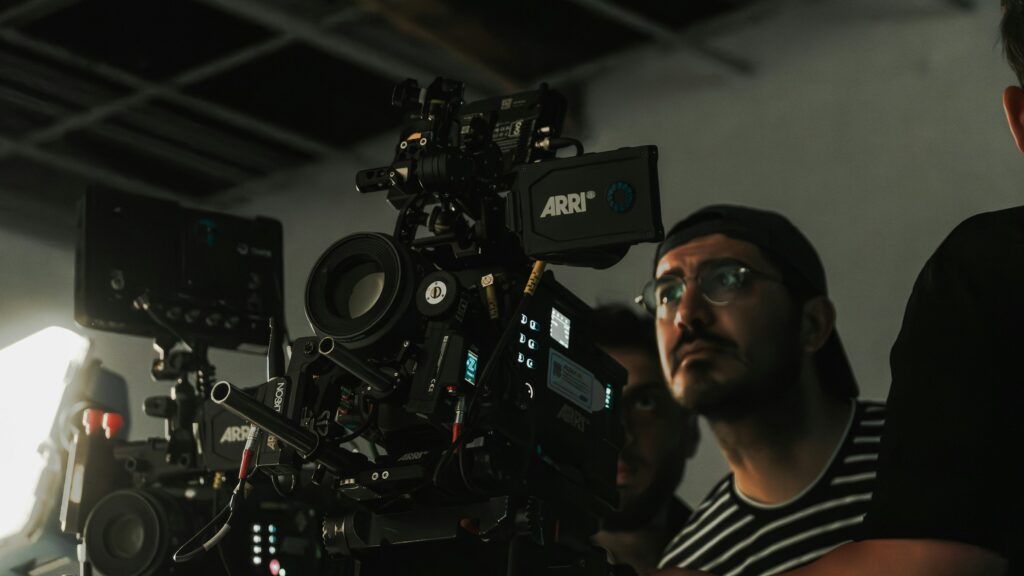 A cinematographer looking up beside a rigged ARRI camera in a studio