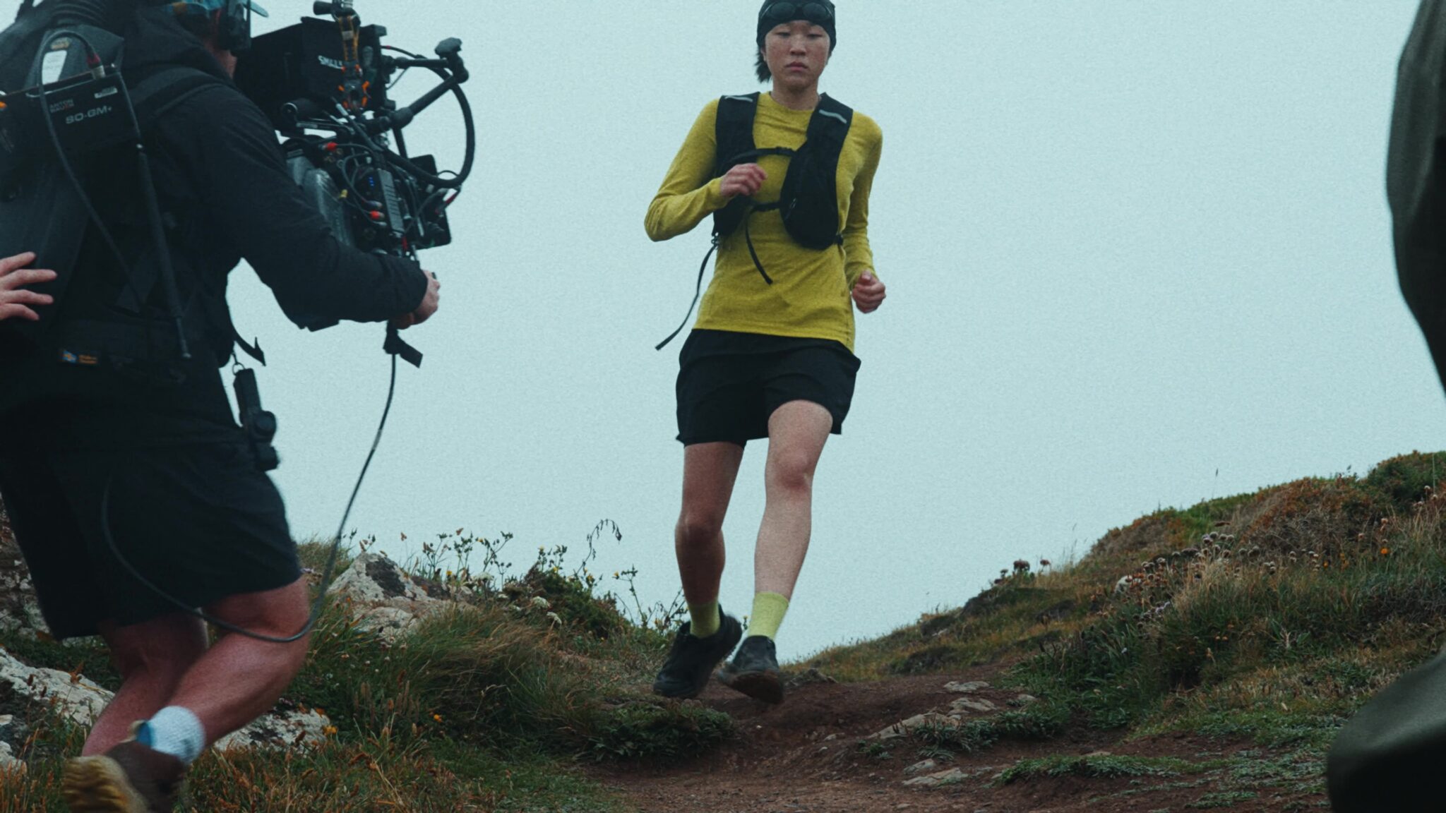 Our camera operator following a runner along a clifftop path in fog, on the Lizard for Cohere