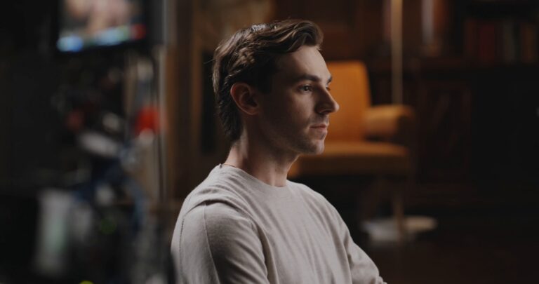 Mark Swan in profile in the library set
